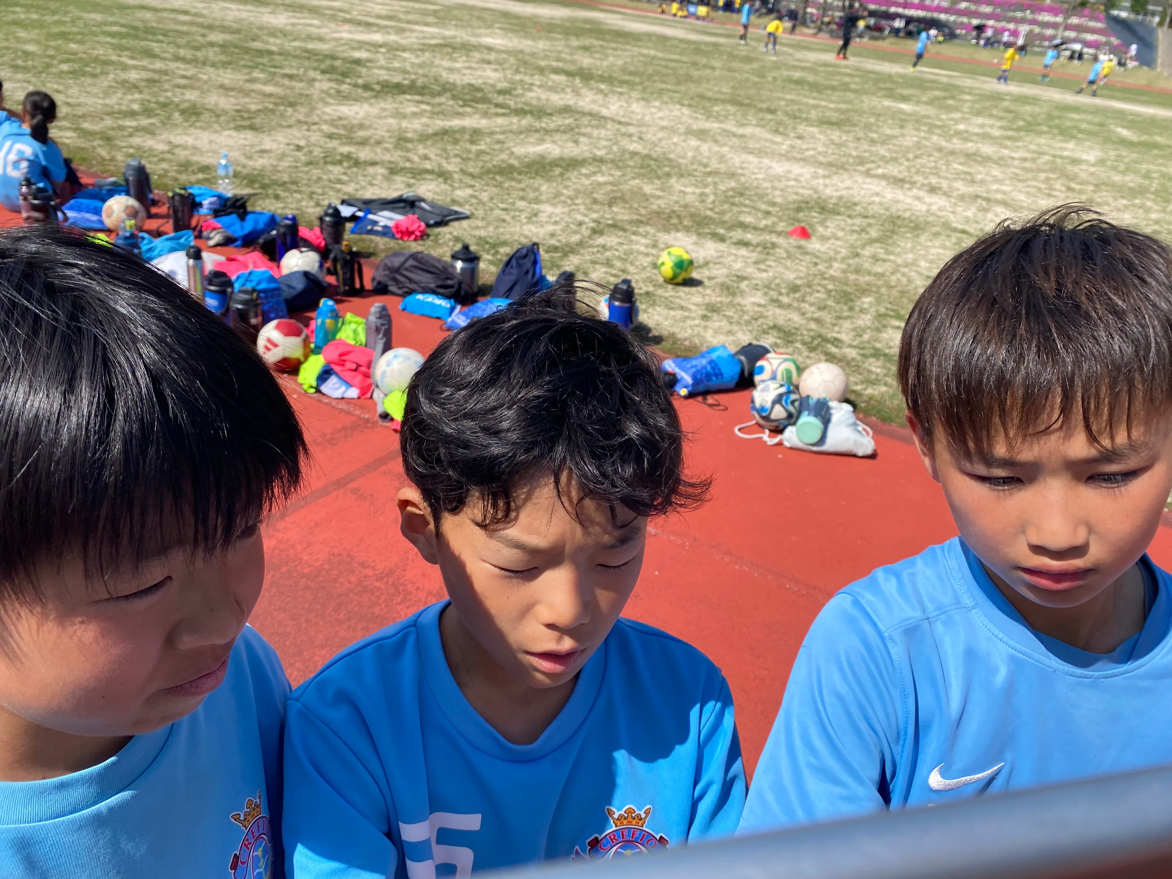 陸上競技場のトラック脇に並ぶ選手たち