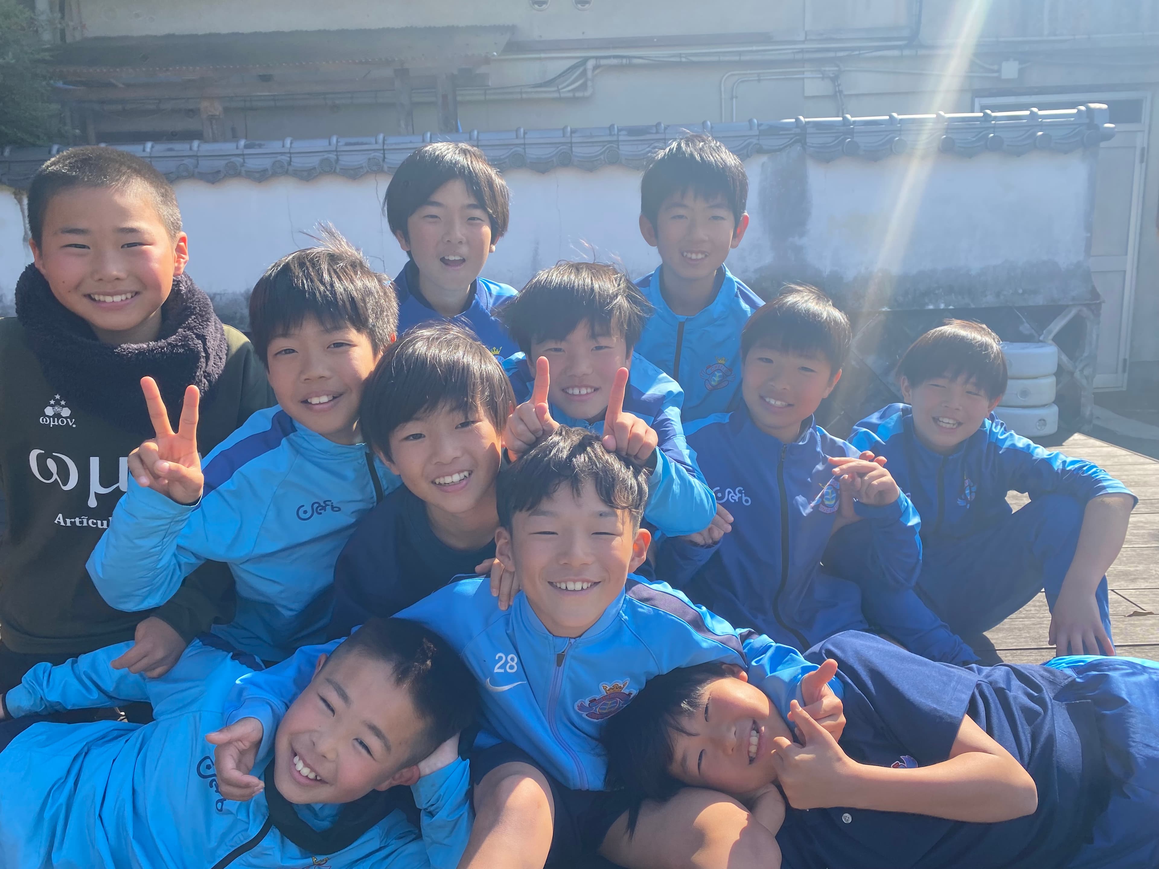 屋外でジャージ姿の選手たちが集まる様子